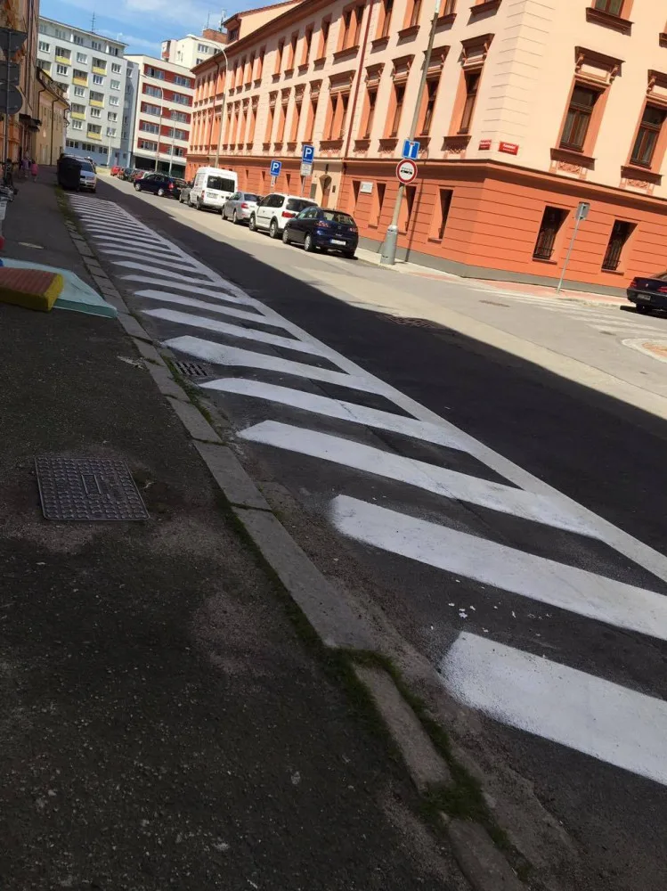 Bílé šrafování na křižovatce ulic Kostelní a Skuherského