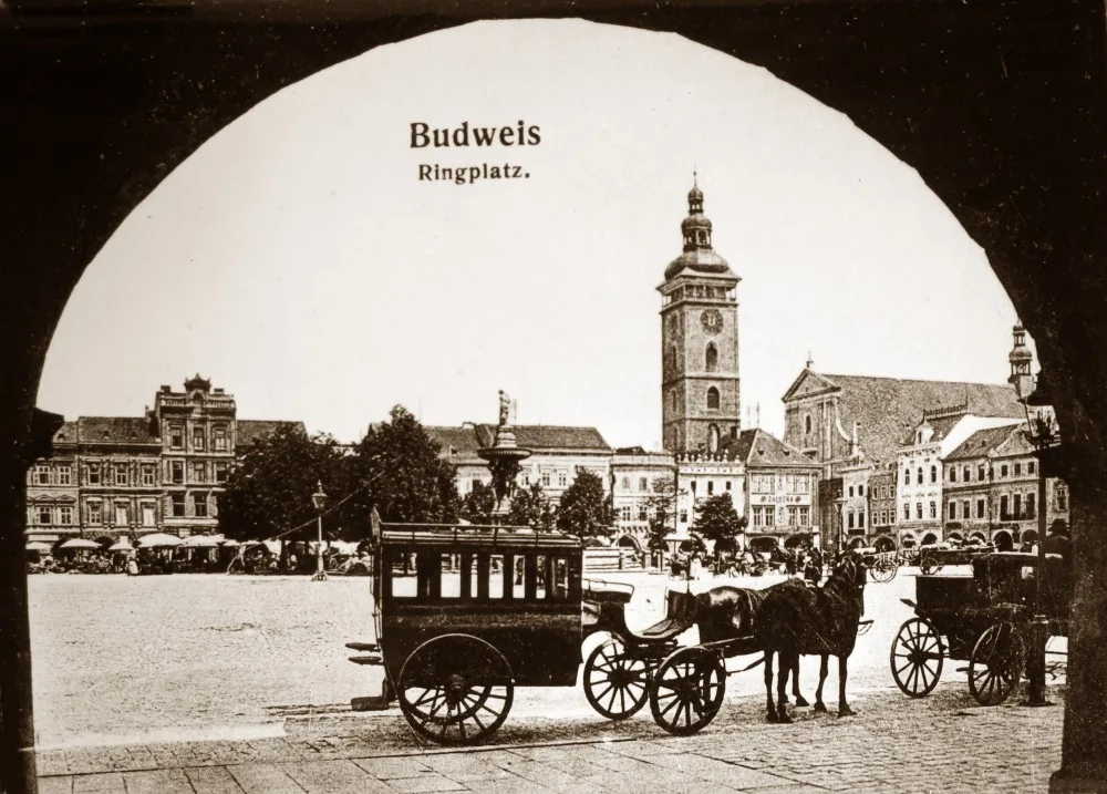 Na snímku pořízeném před rokem 1908 stojí na jižní straně náměstí přibližně před hotelem U Zlatého slunce dva fiakry.