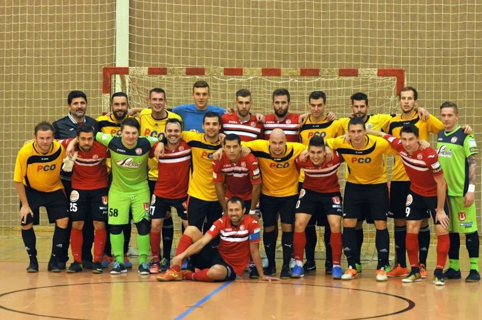 Hráči PCO Rudolfov po loňském střetnutí s Benagem (v červeném) v hale budějovické Lokomotivy, kde se v pondělí střetnou s Teplicemi.