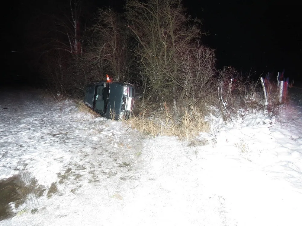 Opilý řidič převrátil auto na zledovatělé silnici. Poničil pomníček z dřívější tragické nehody