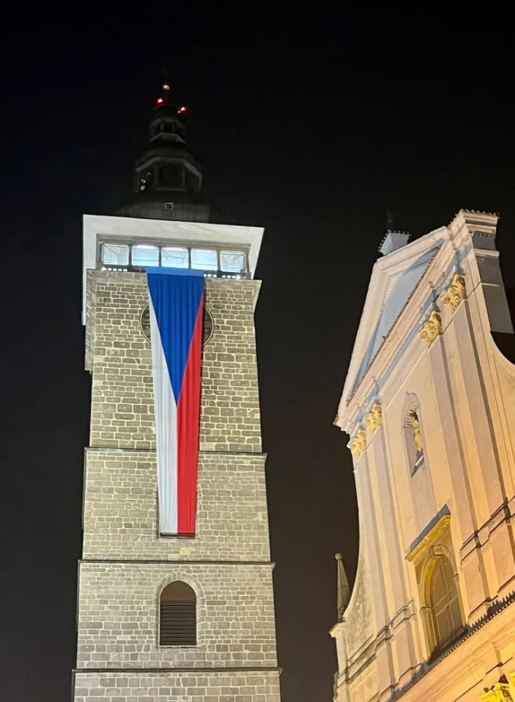Černou věž zdobí česká vlajka.