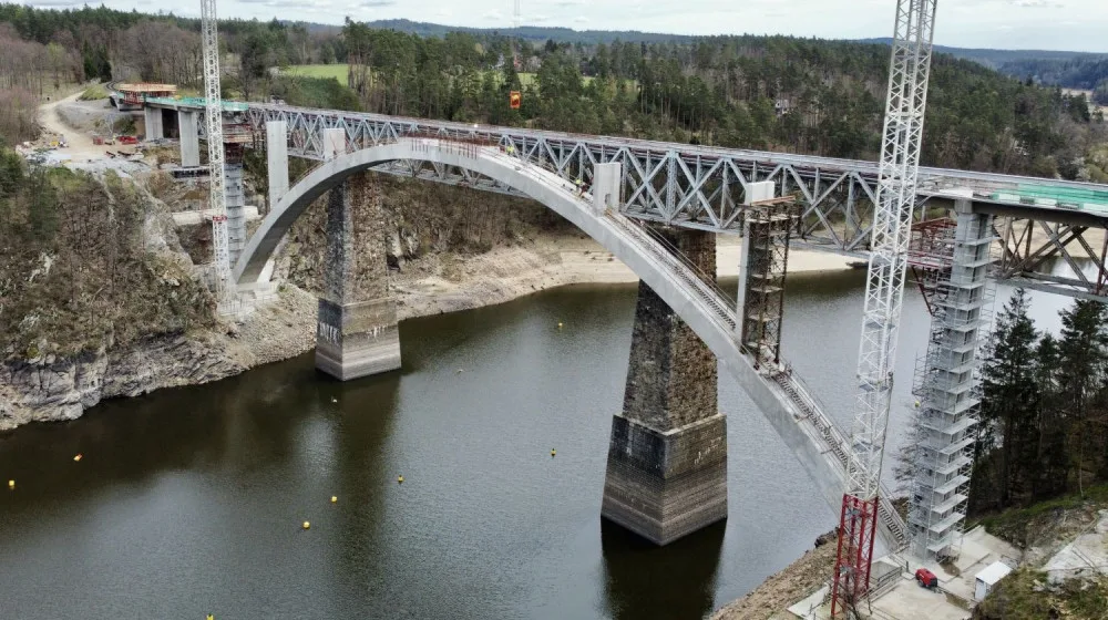 Stavbaři vybetonovali pilíře nad obloukem nového železničního mostu přes Orlík
