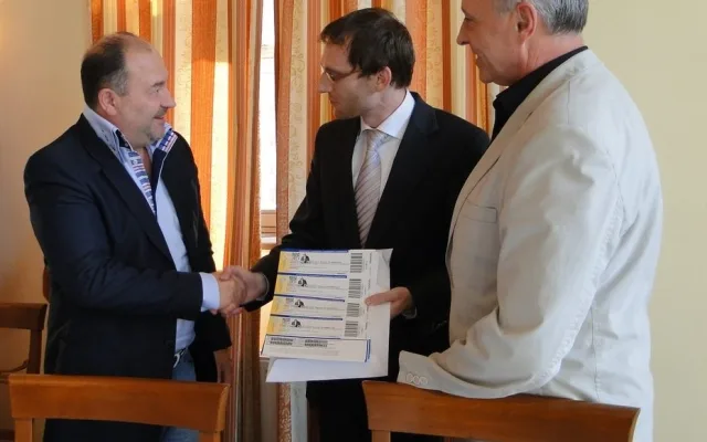 Michal David předává lístky pro děti a seniory zástupcům města