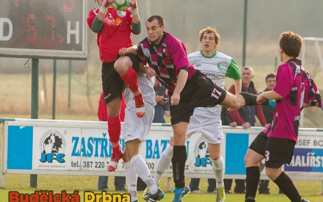 Brankář Roudného Jiří Komrska v akci, atakovaný Lukášem Dudkem