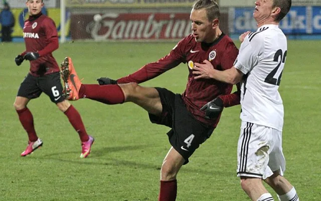 Hostující Ondřej Švejdík odkopává balon před Petrem Benátem