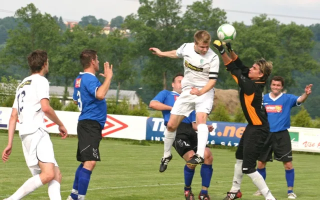 Kapitán Roudného Libor Matoušek hlavičkuje před gólmanem Ramsem při jihočeském derby s Čížovou. Foto: Milan Šíma, www.jihoceskyfotbal.cz