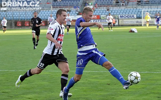Jan Peterka odkopává míč před Petrem Benátem