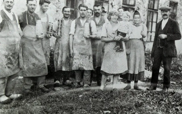 Brusiči skla se svými výrobky před budovou sklárny v Josefově Dole v roce 1928.