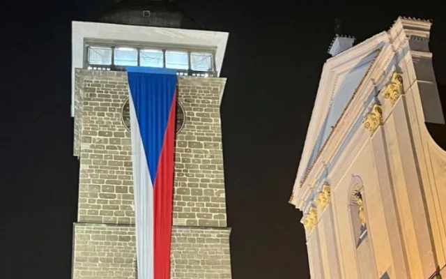Černou věž zdobí česká vlajka.