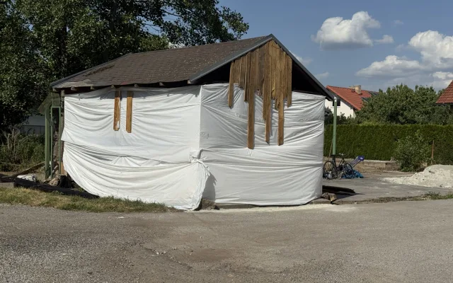 Prodal vilu a teď squattuje na sousedním pozemku. Z přístřešku si buduje provizorní bydlení