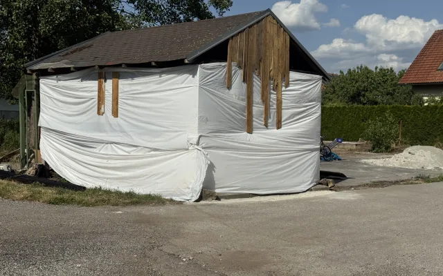 Prodal vilu a teď squattuje na sousedním pozemku. Z přístřešku si buduje provizorní bydlení