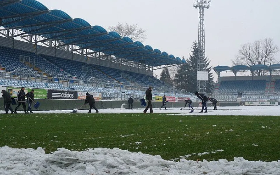 Odklízení sněhu na ploše hlavního stadionu na Střeleckém ostrově je v plném proudu