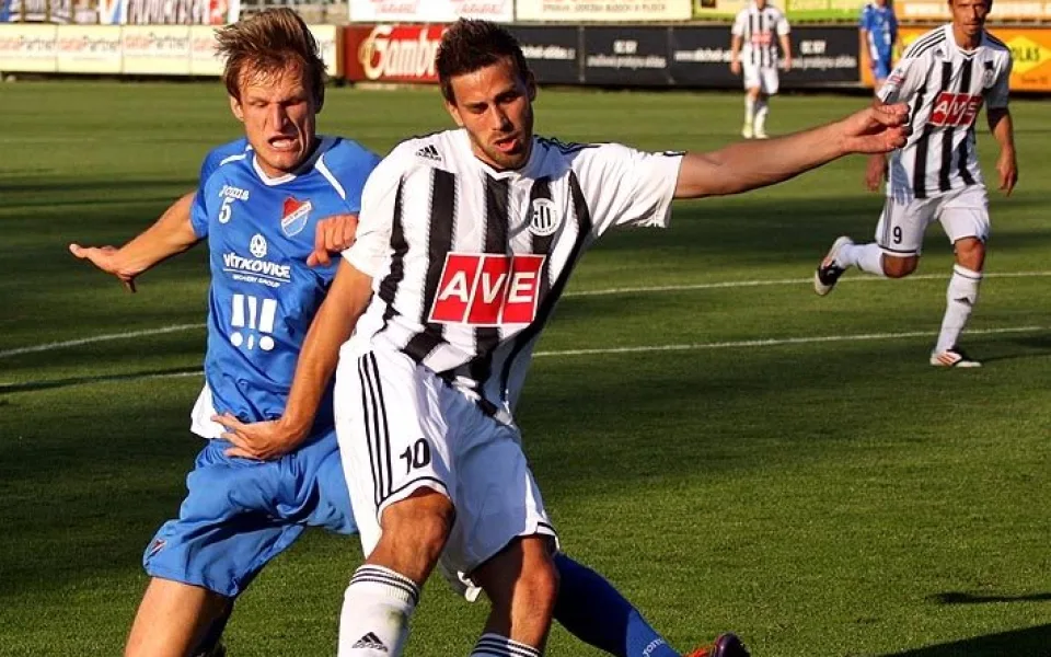 Zavři oči a vystřel! Michal Klesa pálí, skluzem se ho snaží zastavit střelec prvního gólu Baníku Petr Mach