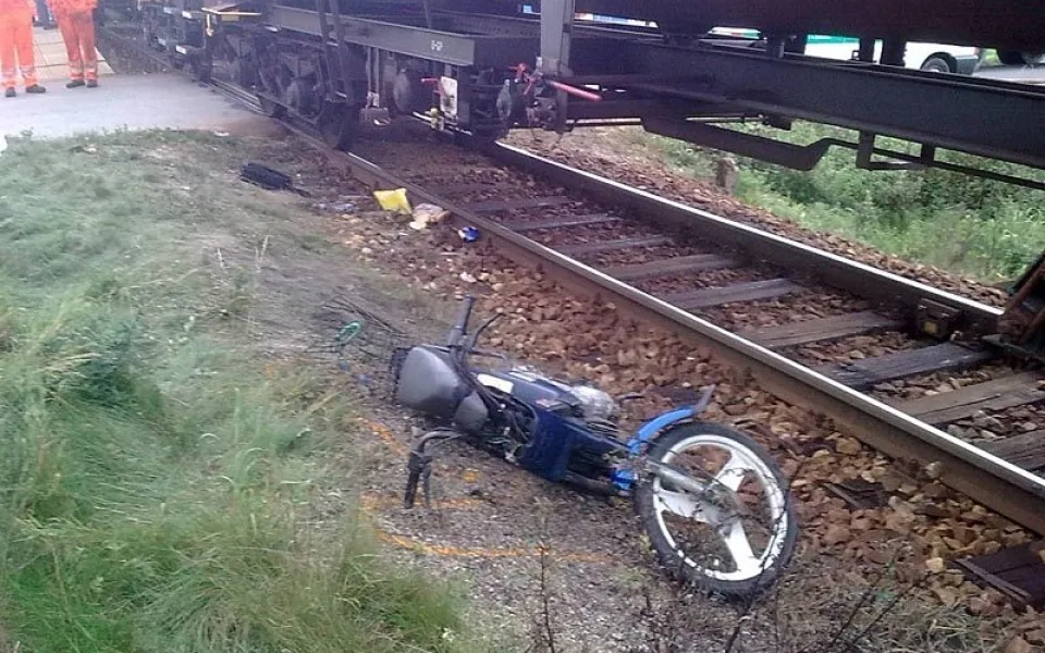 Motocykl ženy, která vjela pod vlak