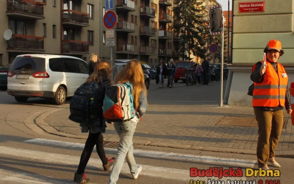 Dobrovolníci pomáhají dětem na přechodech