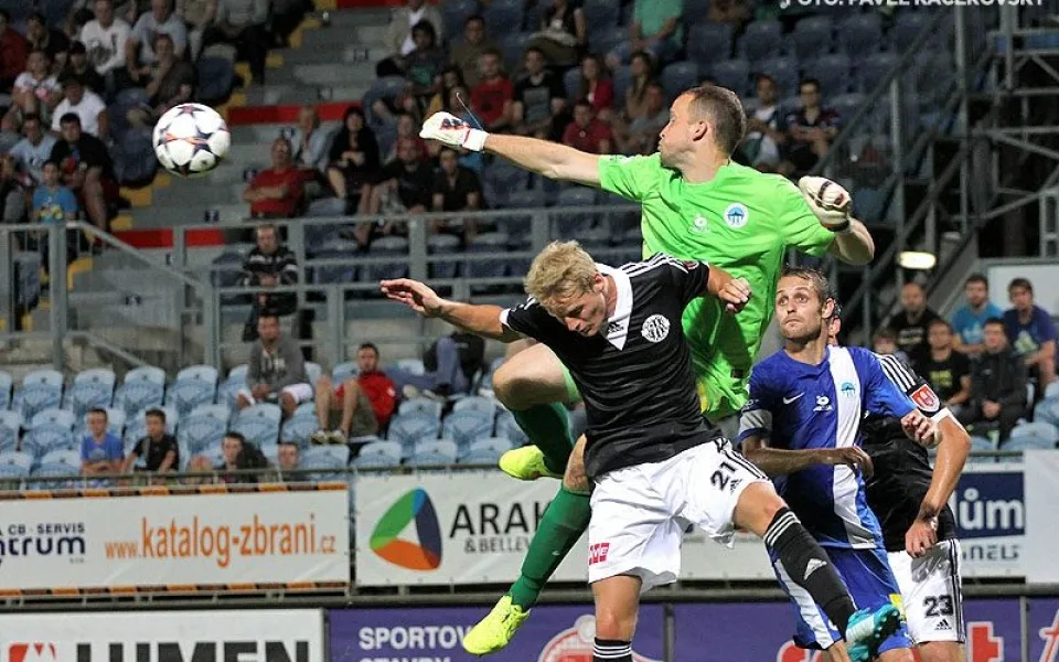Liberecký gólman Lukáš Hroššo vyráží balon před Štěpánem Korešem, autorem branky Dynama