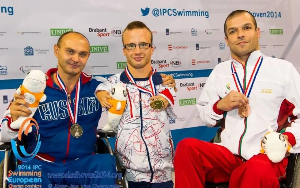 Arnošt Petráček (uprostřed) se zlatou medailí z disciplíny 50 metrů znak