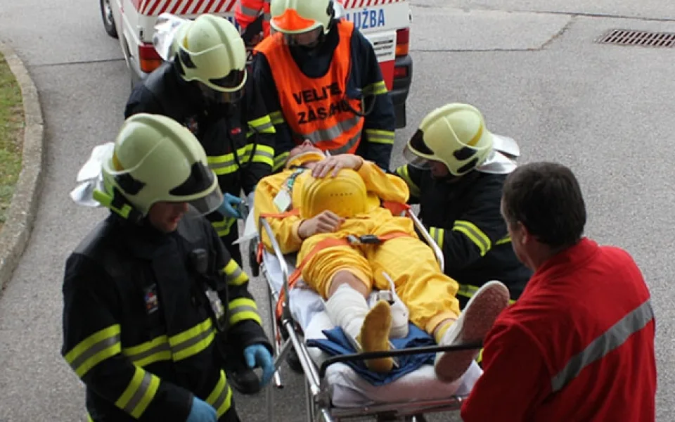 Hasiči odnášejí zraněného pracovníka k dozimetrické kontrole