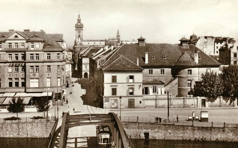 Pravé nábřeží Malše se Savoyí, starým divadlem a benzinovou pumpou v roce 1940. Shodou okolností jede přes Zlatý most tramvaj