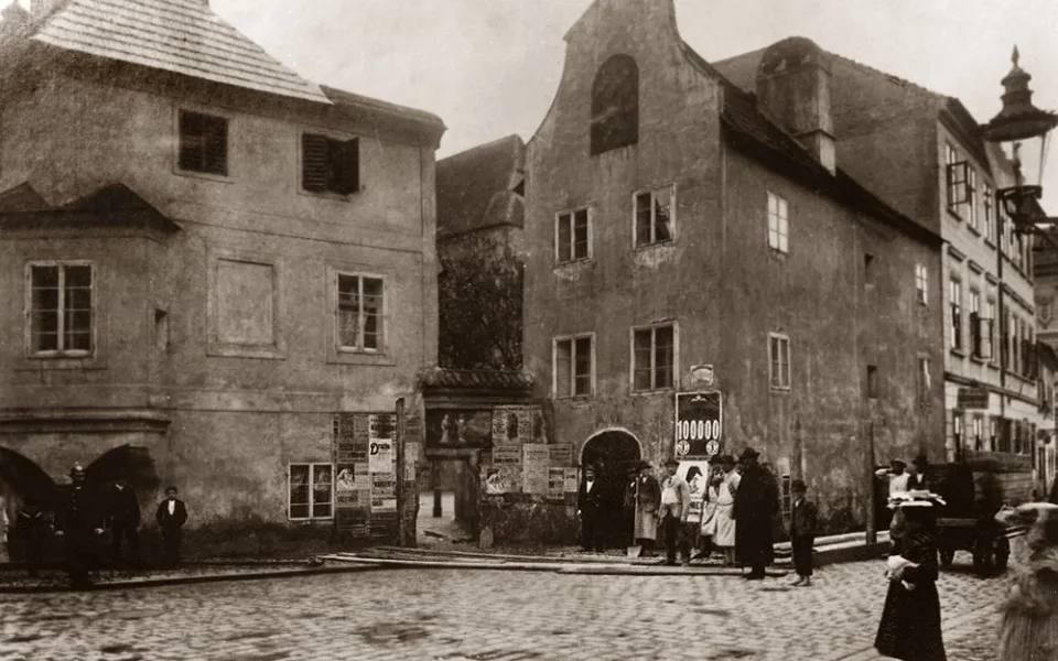 Hroznová ulice s renesančním domem Josefa Schwarzkopfa před rokem 1903. Na Piaristické náměstí, původně na klášterní hřbitov, vedla brána