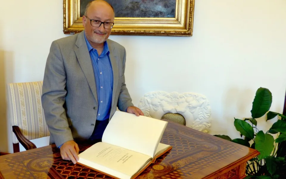Primátor Jiří Svoboda listuje pamětní knihou.