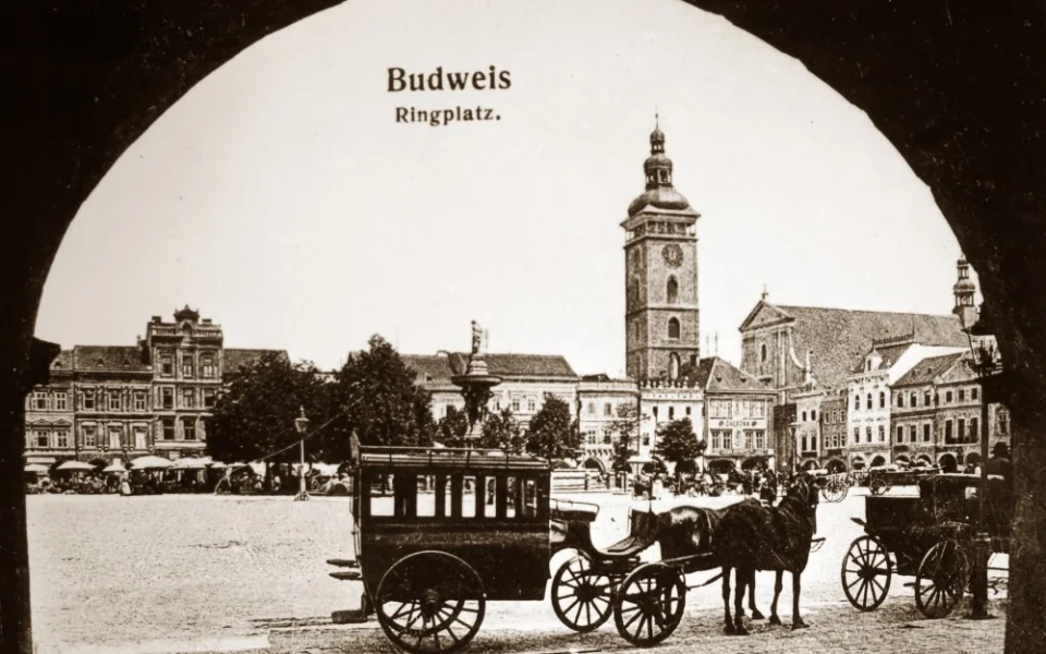 Na snímku pořízeném před rokem 1908 stojí na jižní straně náměstí přibližně před hotelem U Zlatého slunce dva fiakry.