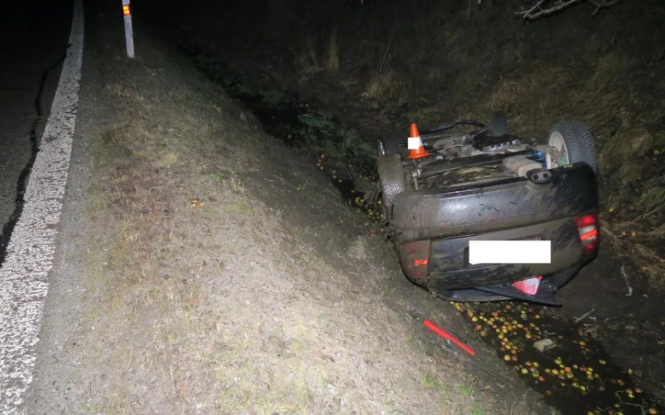 Řidič dostal na mokré silnici smyk a narazil do stromu. Auto zůstalo po nárazu na střeše