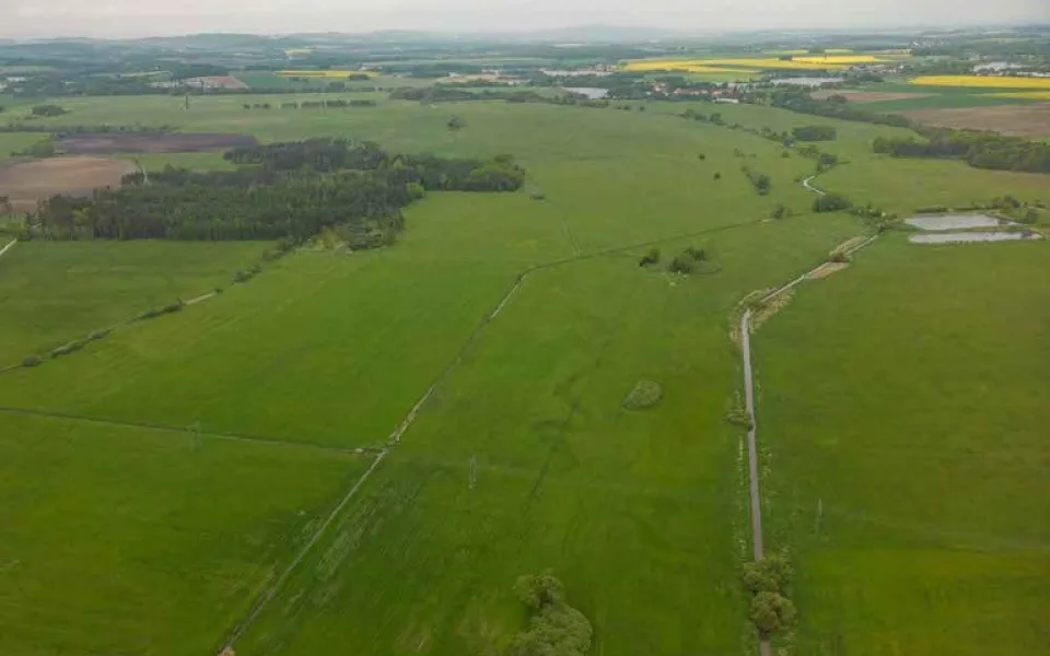 Na leteckém snímku Zbudovských Blat je dosud patrné, kudy meandroval Bezdrevský potok (střed snímku) než ho regulovali do rovného koryta vpravo. ČSO chce v budoucnu původní koryto obnovit.