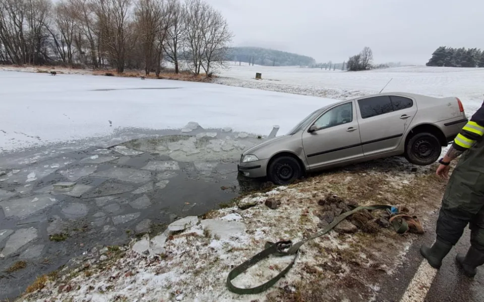Řidič dostal na ledovce smyk a skončil s autem v rybníce. Silnice mohou namrzat i v noci na čtvrtek