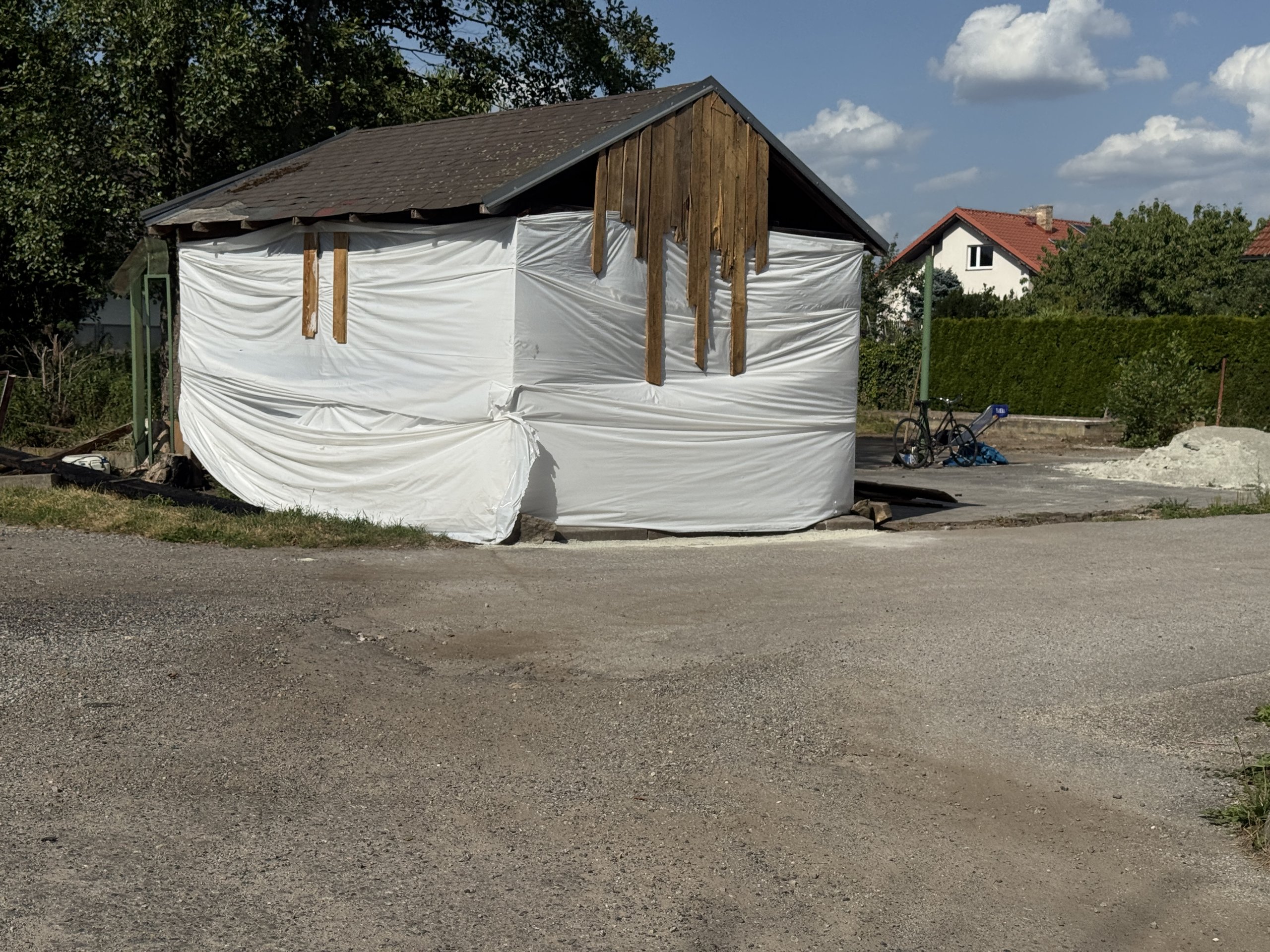 Prodal vilu a teď squattuje na sousedním pozemku. Z přístřešku si buduje provizorní bydlení