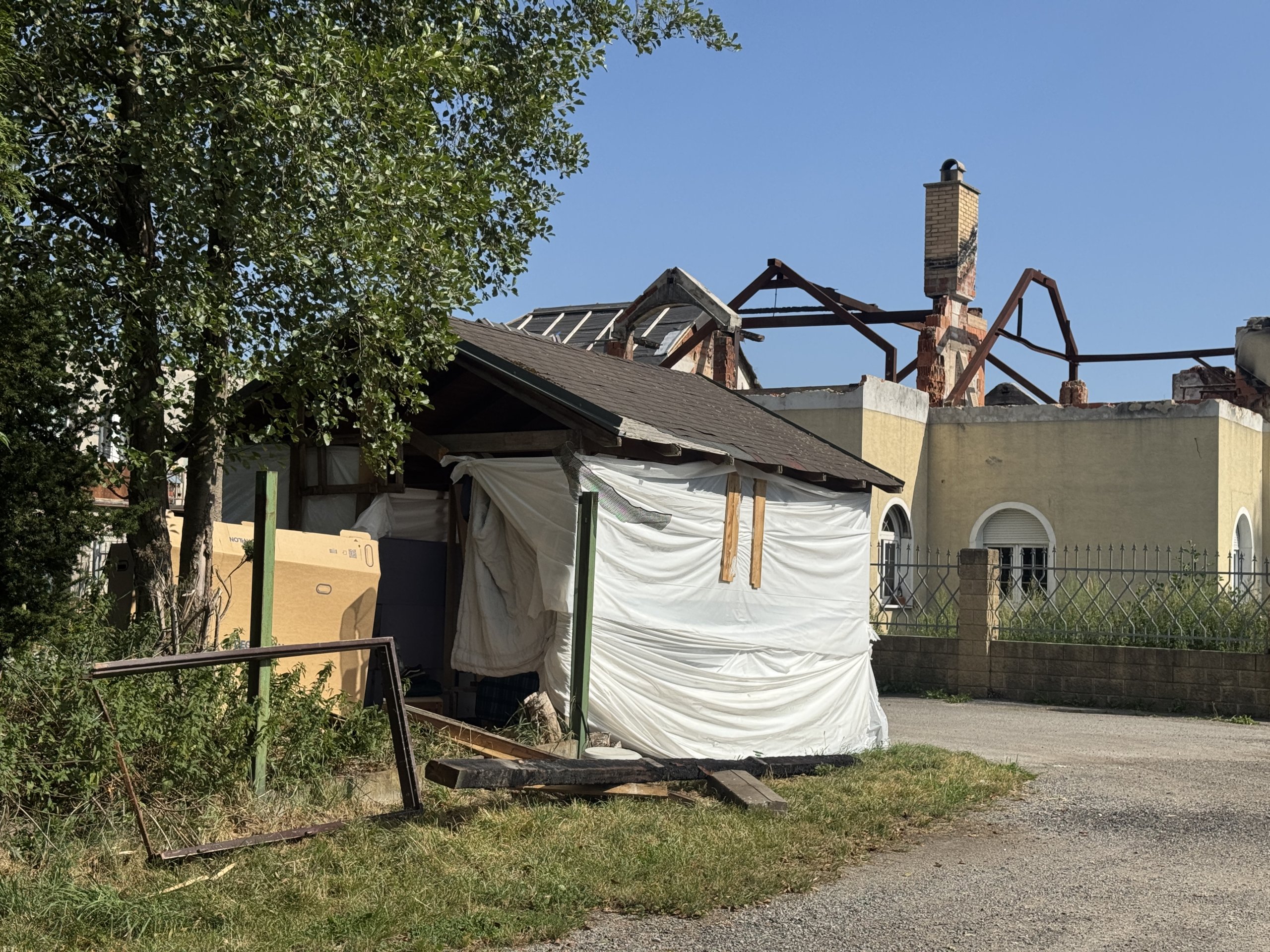 Prodal vilu a teď squattuje na sousedním pozemku. Z přístřešku si buduje provizorní bydlení