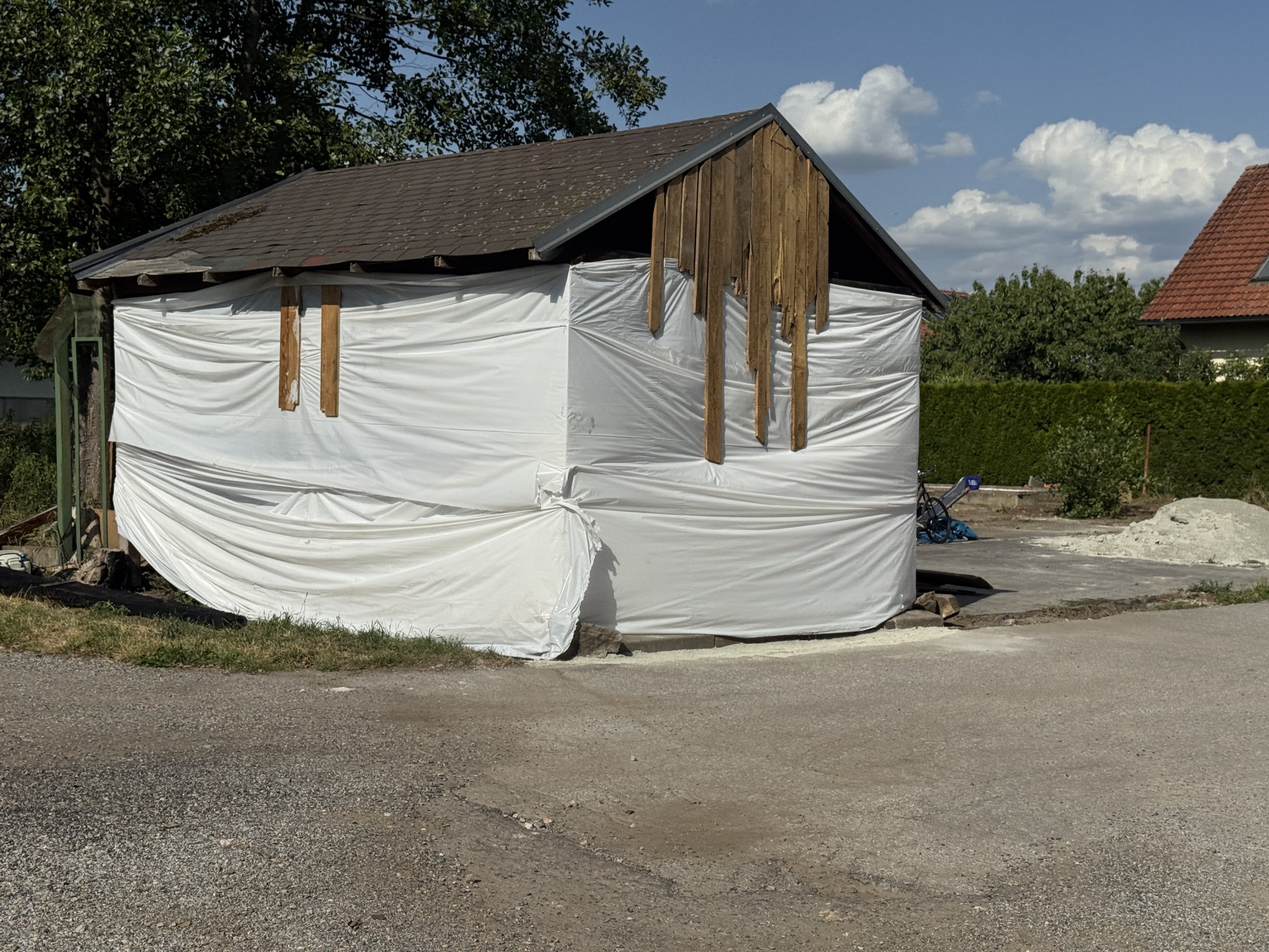 Prodal vilu a teď squattuje na sousedním pozemku. Z přístřešku si buduje provizorní bydlení